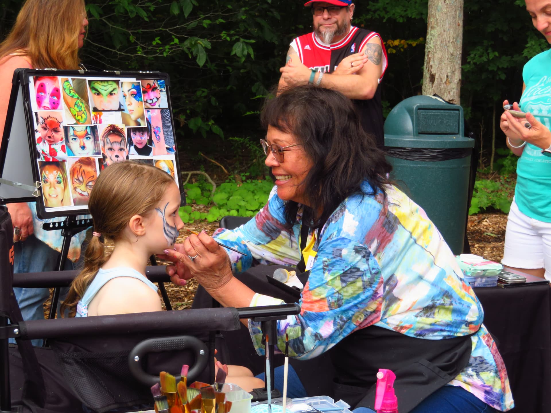 Linda Conroy painting a child's face at the face painting station