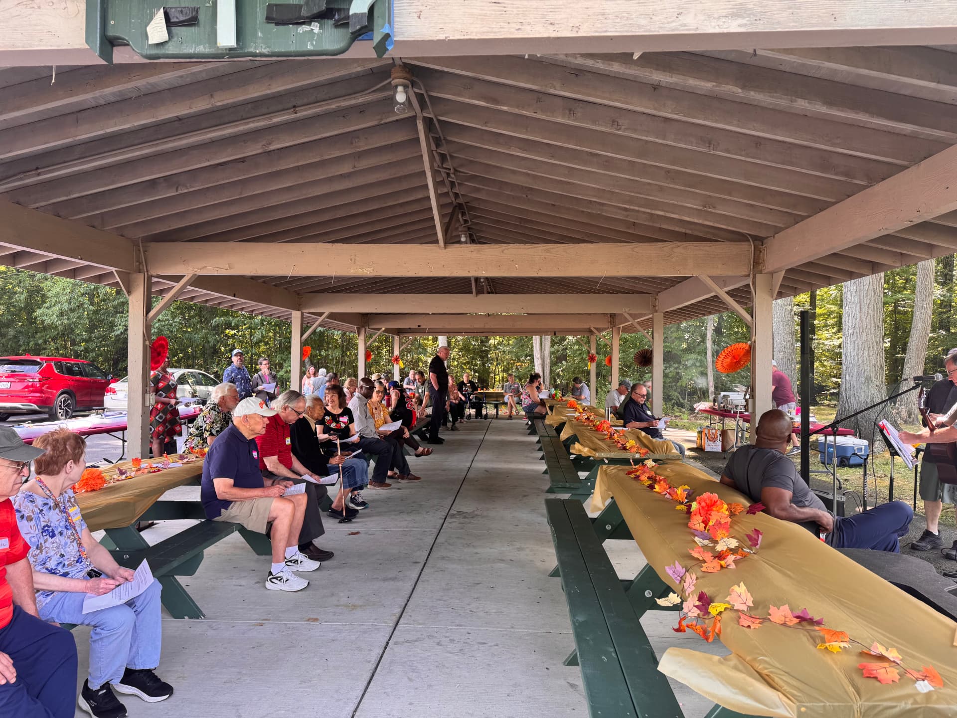 Members seated along the pavilion tables during the program