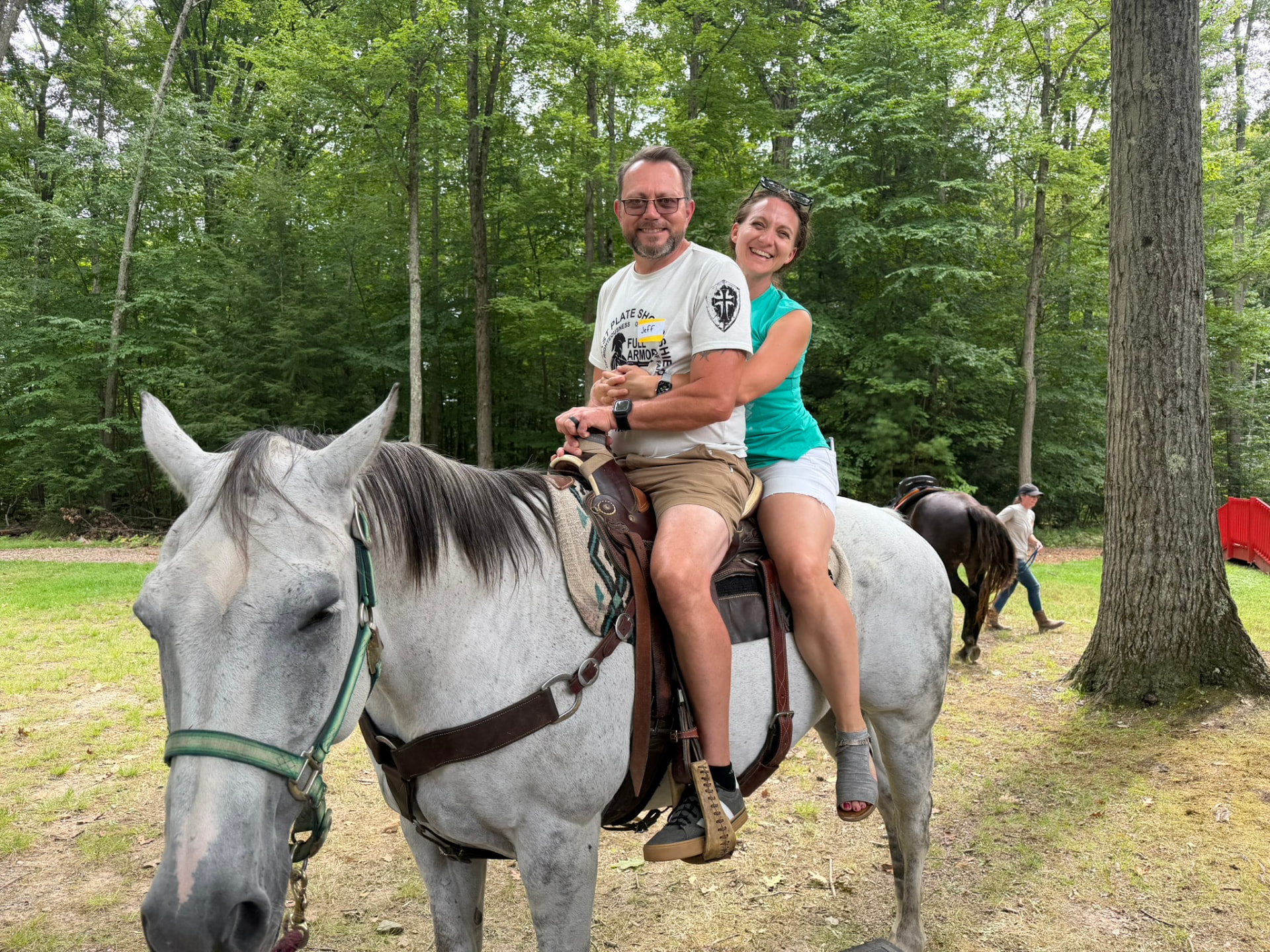 A couple riding horseback together at the picnic
