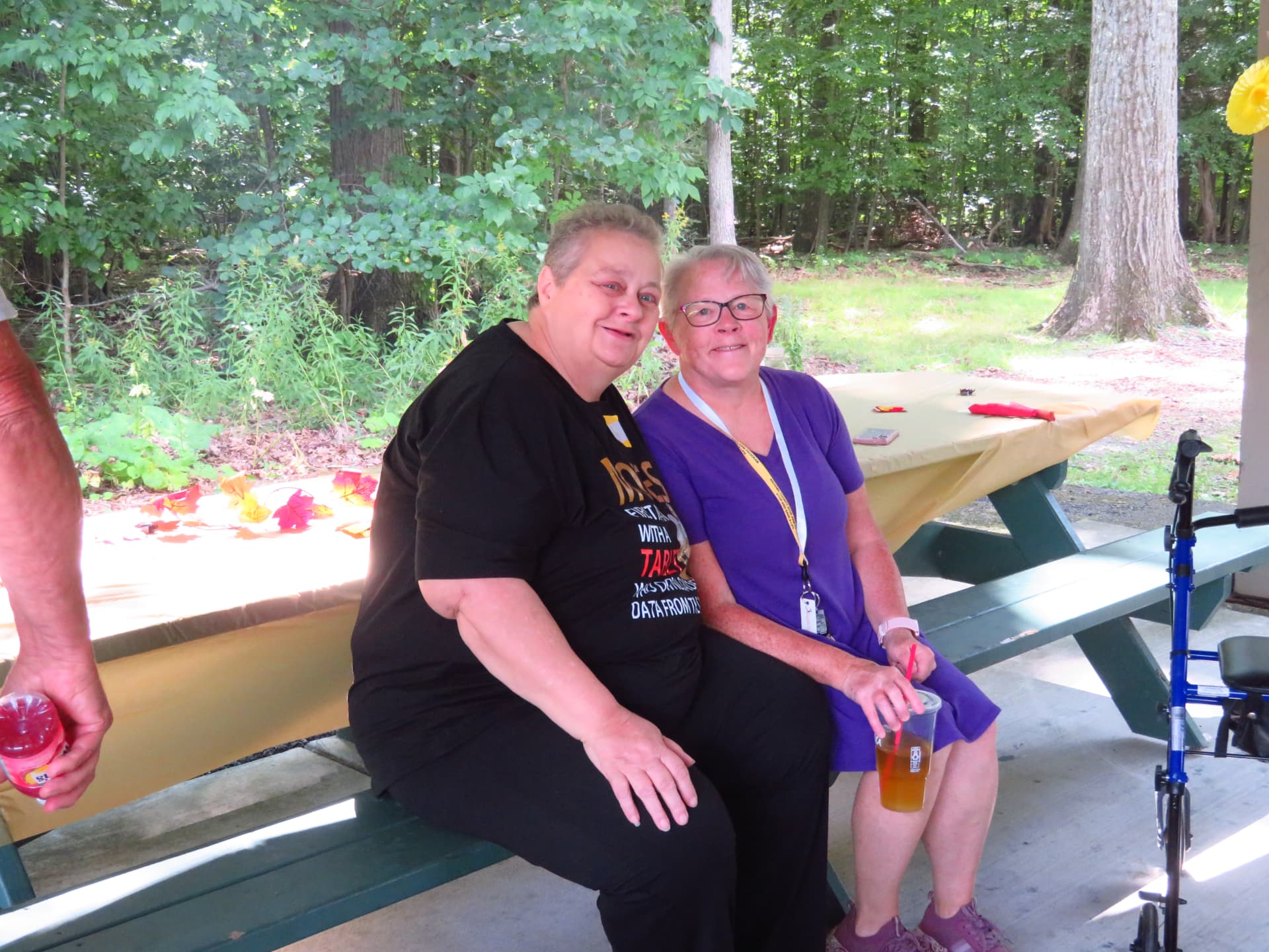 Two members smiling together on a pavilion bench