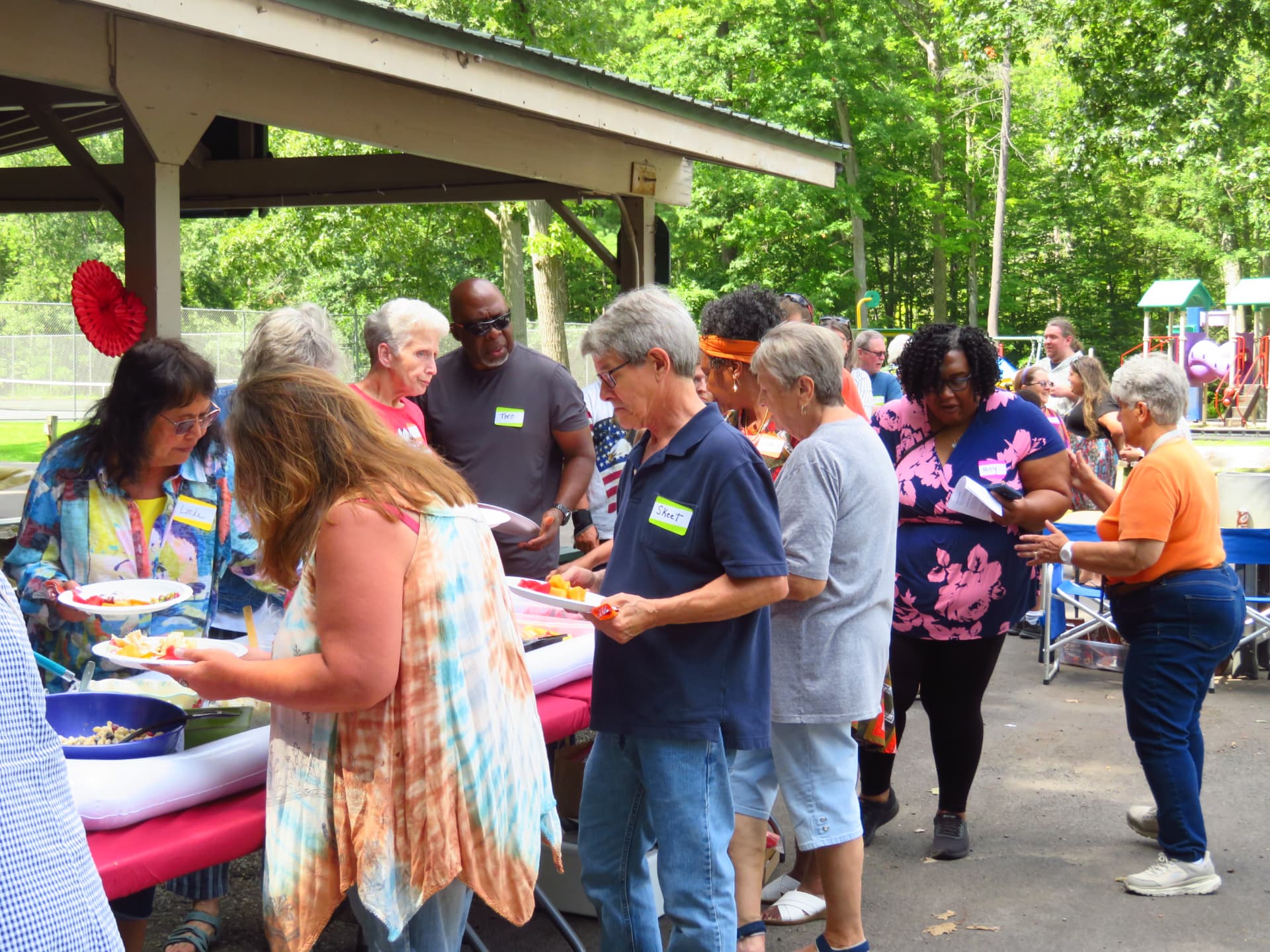 Attendees filling their plates along the picnic buffet line