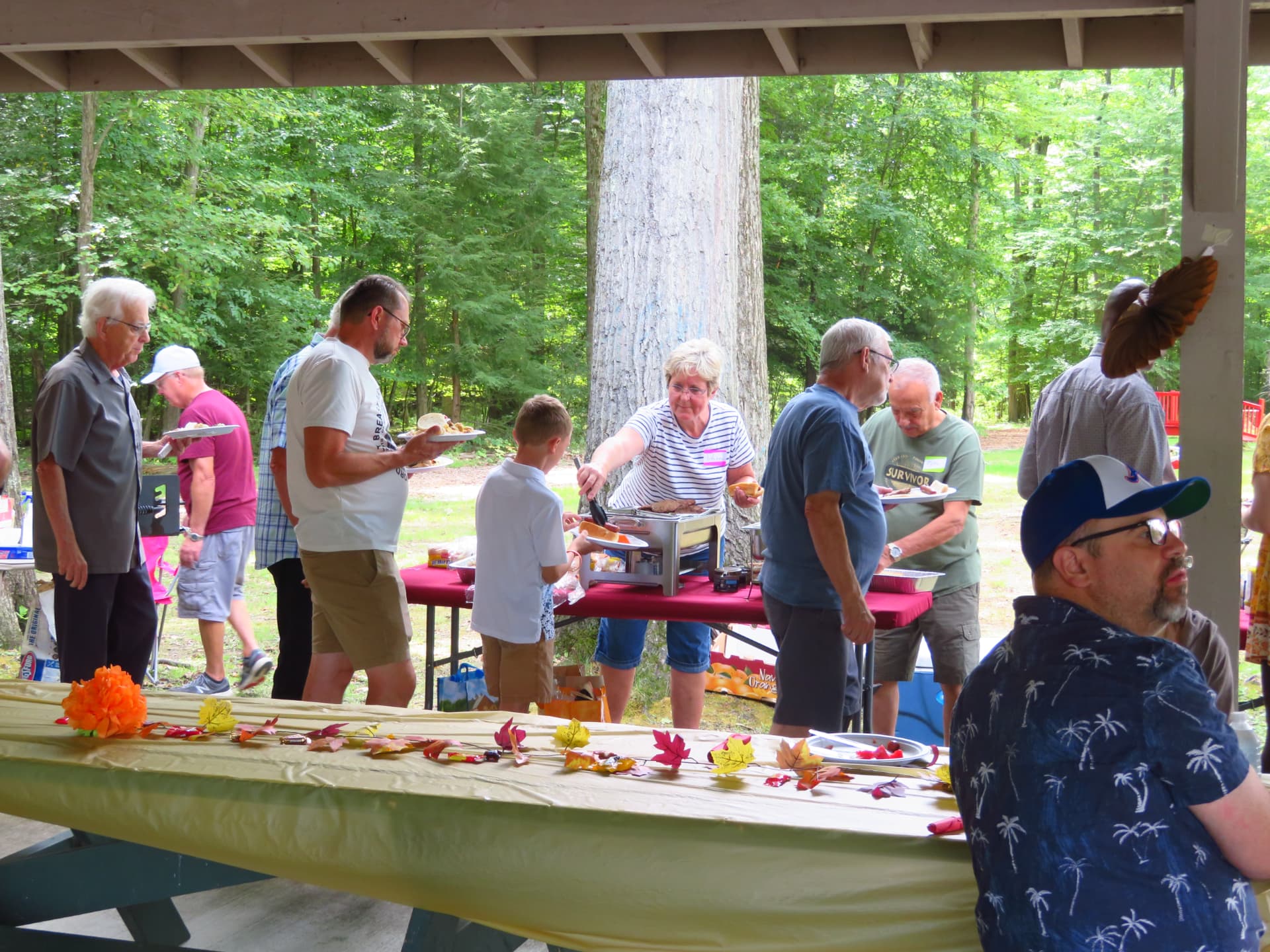 Volunteers serving grilled food along the buffet table